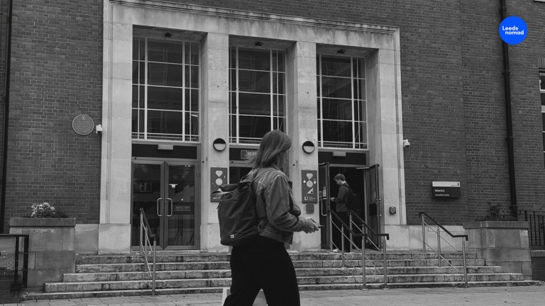 Black and white photo of the Art-Deco Refectory with someone walking past.