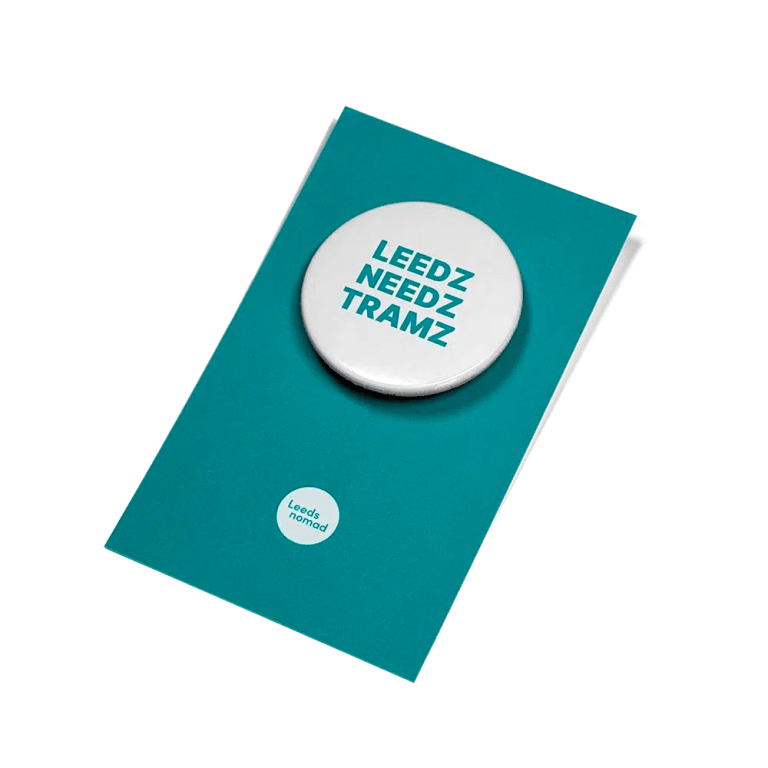 Leedz Needz Tramz white badge on teal coloured backing card.
